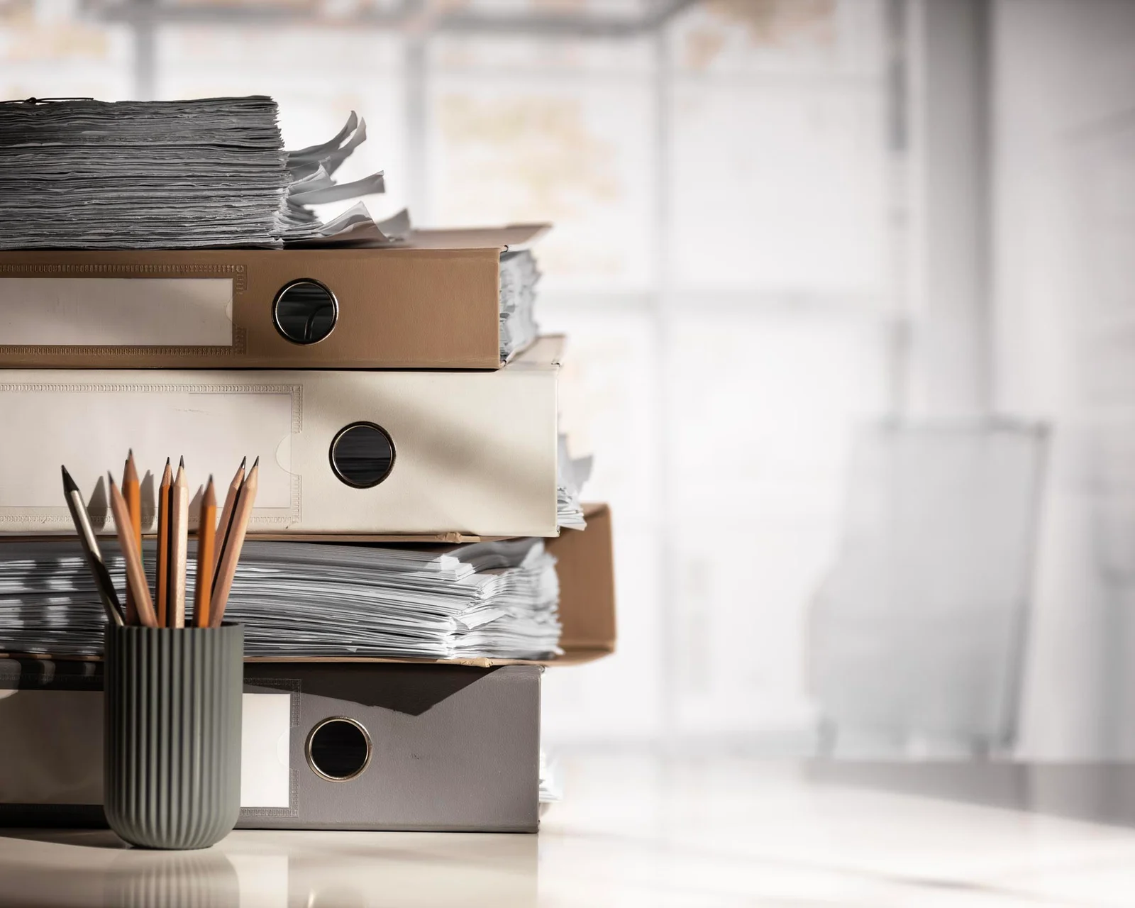 Classeurs et dossiers empilés sur un bureau
